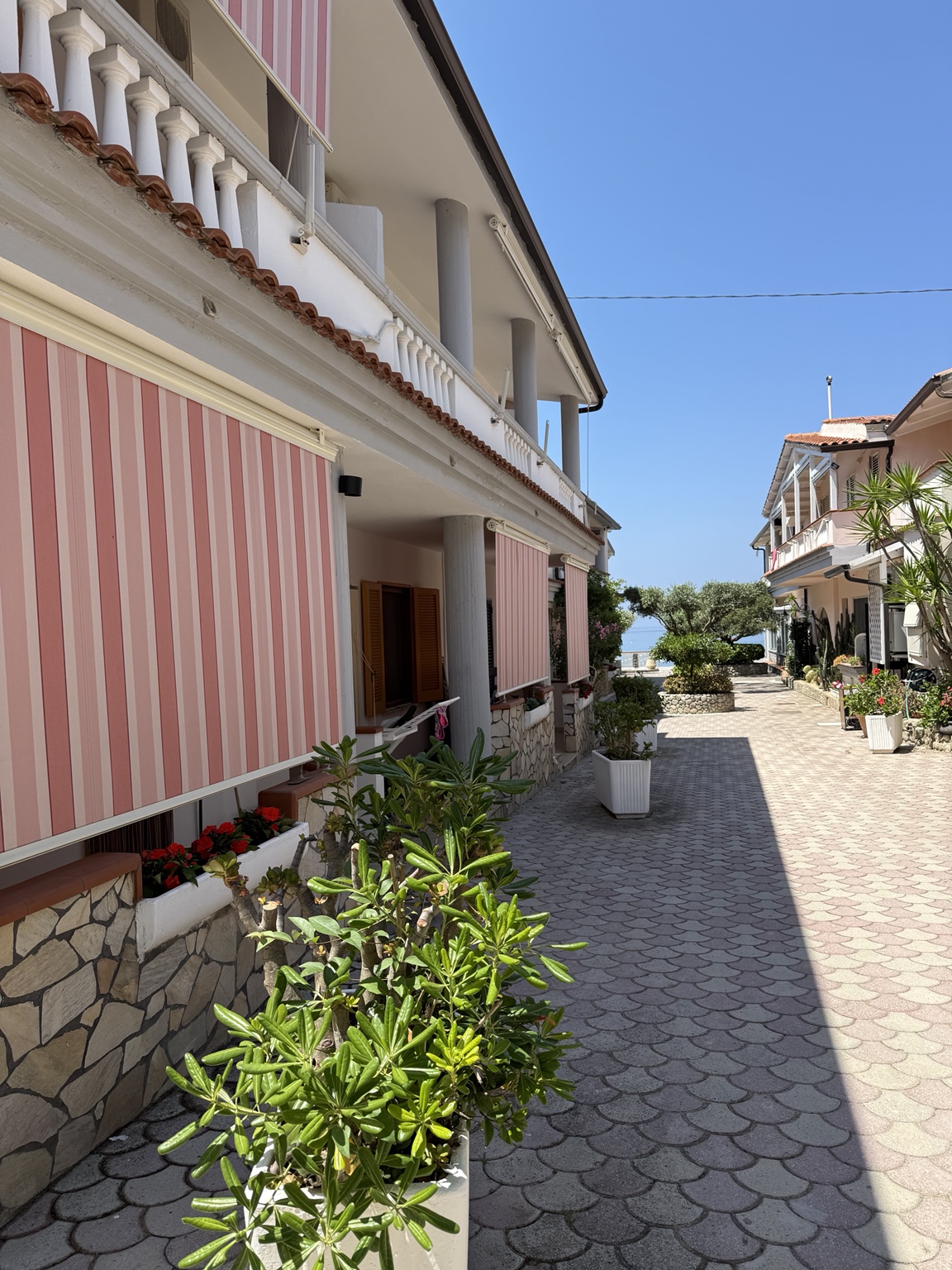 Esterno del residence con viale e mare sullo sfondo